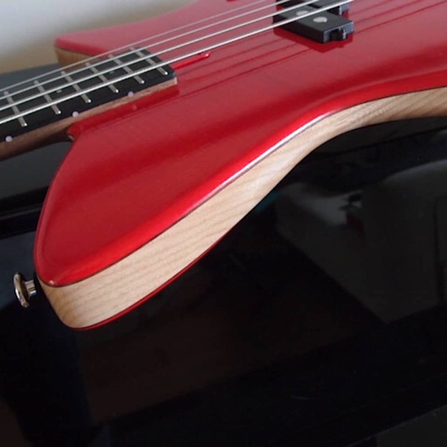 Griffe-Bass: corps en frêne entre table et dos teintés rouge. L'attache courroie est bien avancé pour procurer un bon équilibre de la basse. Le manche traversant permet les découpes profondes qui donnent un meilleur accès aux aigus. Une attention particulière est donnée à l'élévation de la touche par rapport à la table pour faciliter le jeu aux doigts et le slap.